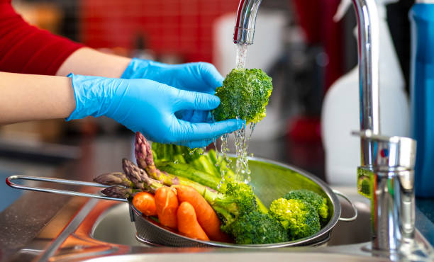 Woman washing vegetables on kitchen counter
